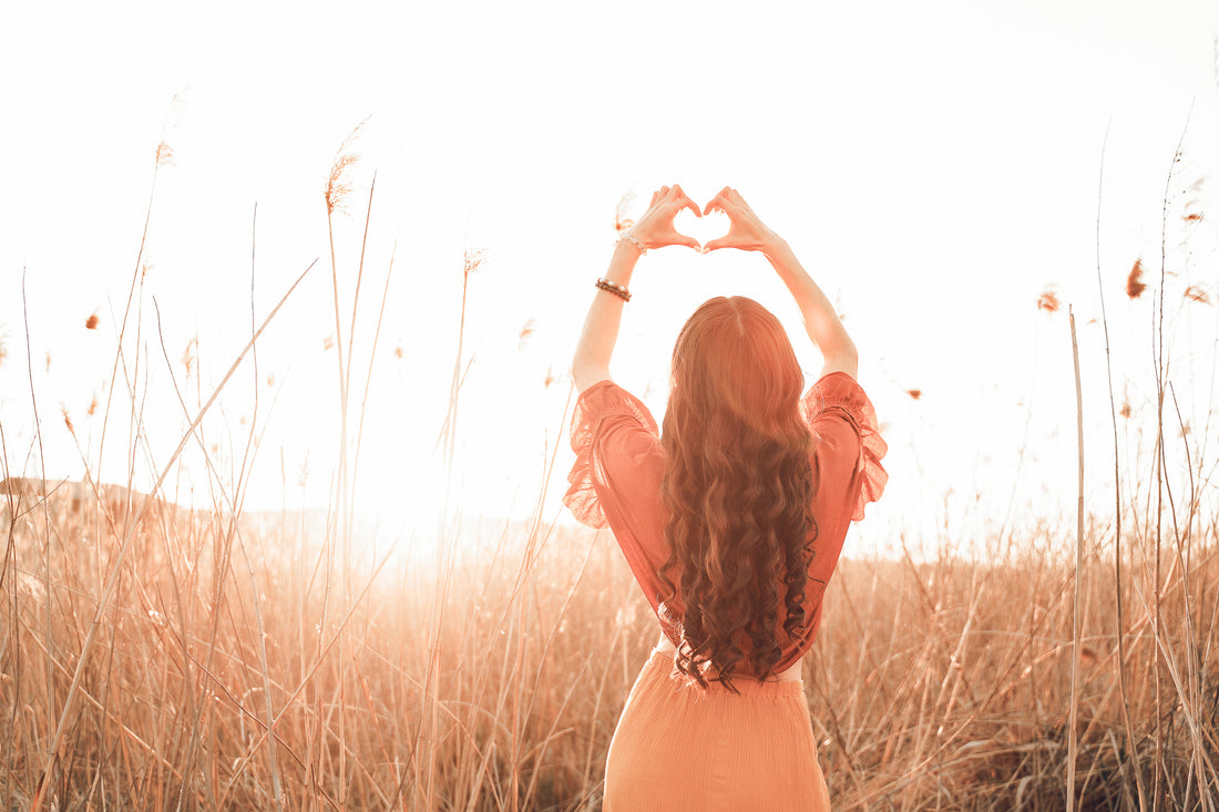 Stylish woman spending time in a summer field, practicing self-love